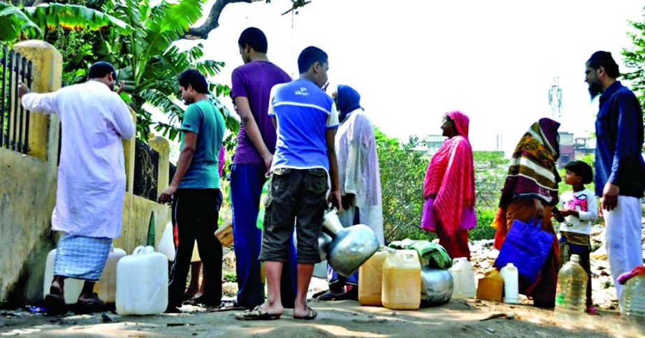 Locals queue up in front of a WASA water pump at New Paltan area of Azimpur to collect drinking water in the wake of crisis in the area on Sunday.