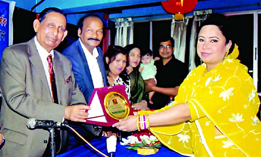 Justice Joynal Abedin handing over 'Alokito Nari-2014' prize to the Chairperson of Asha Coaching Center, Dewan Shahnaz Akter at a ceremony organized by Swadesh Sangbadik Foundation at a hotel in the city on Thursday.
