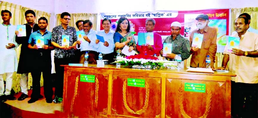 Participants hold the copies of a book titled 'Swapnik' at its cover unwrapping ceremony held recently in the Seminar Hall of Public Library in the city.