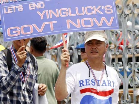 An anti-government protester from the Network of Students and People for Thailand's Reform holds a placard during a rally at Government House in Bangkok on Saturday.