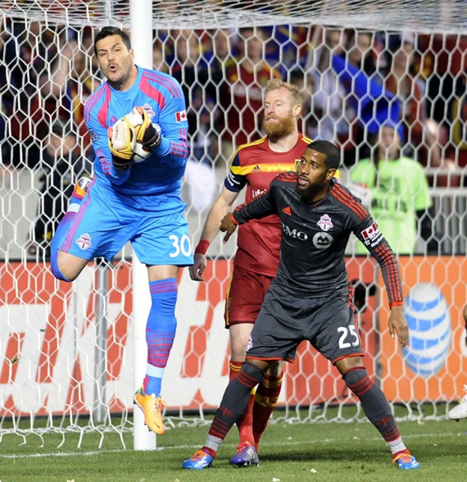 Toronto FC goalkeeper Julio Cesar (30) grabs a shot on goal as Toronto FC defender Jeremy Hall (25) and Real Salt Lake defender Nat Borchers watch during an MLS soccer game on Saturday at Utah. Real Salt Lake won 3-0.