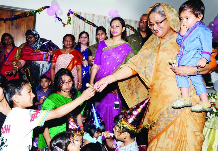Prime Minister Sheikh Hasina giving chocolates and other gifts among the children of SOS Palli in the city's Shyamoli area on Sunday when she visited there. BSS photo
