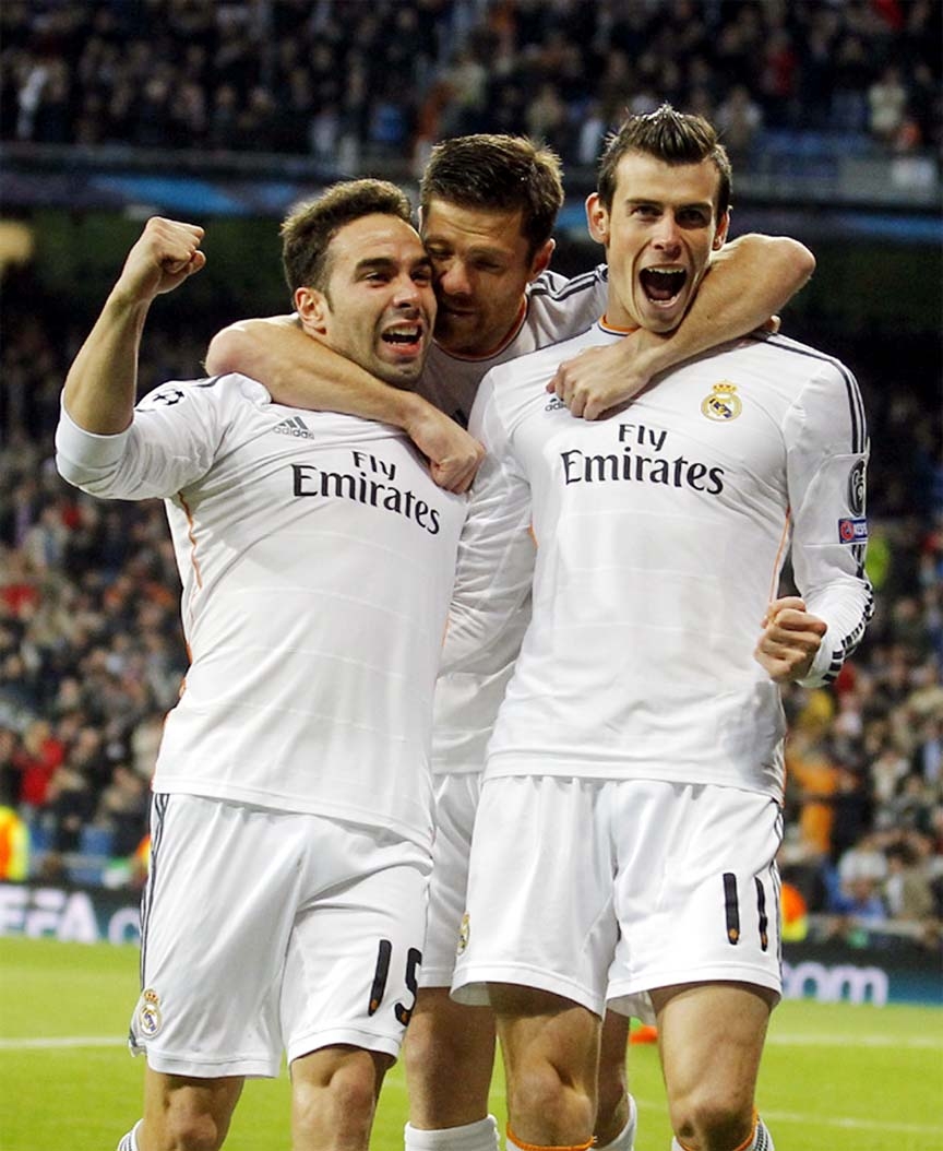 Real's Gareth Bale (right) celebrates scoring the opening goal with Real's Daniel Carvajal (left) and Xabi Alonso center during a Champions League quarterfinal first leg soccer match between Real Madrid and Borussia Dortmund at the Santiago Bernabeu S