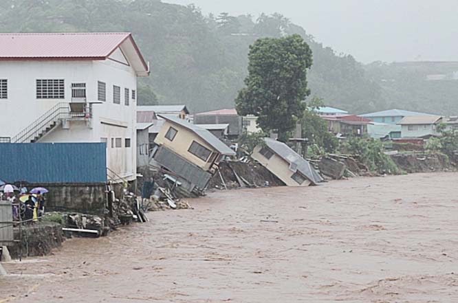 Flood waters run past damaged homes in the Solomon Islands capital of Honiara. Entire houses have been washed away by the flood water