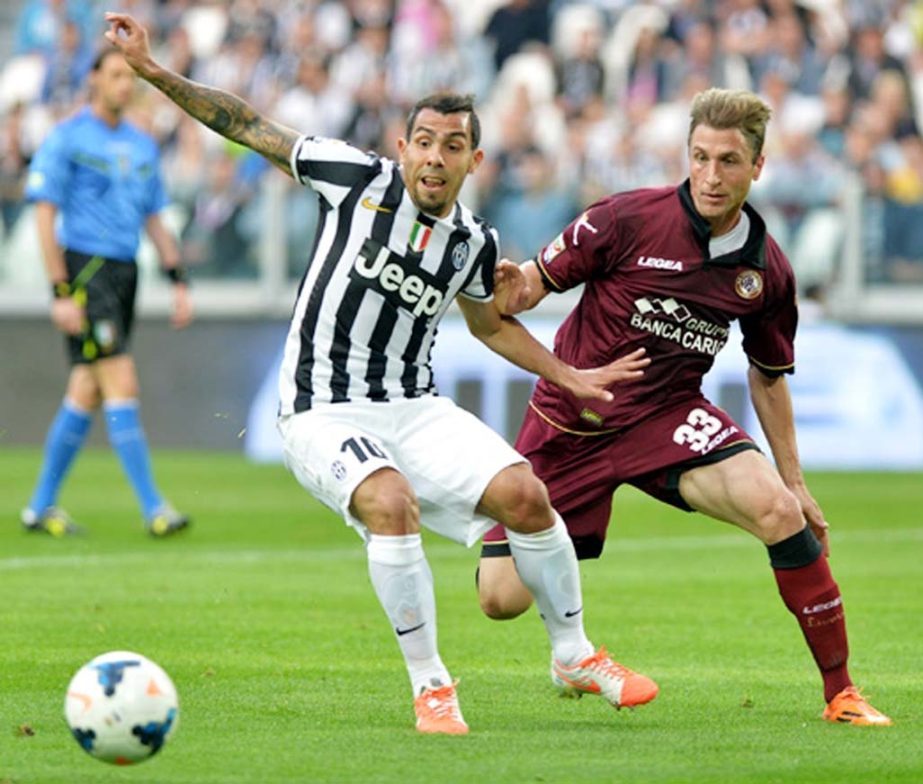 Juventus forward Carlos Tevez of Argentina (left) challenges the ball with Livorno Nahuel Valentini during a Serie A soccer match between Juventus and Livorno at the Juventus stadium in Turin Italy on Monday.