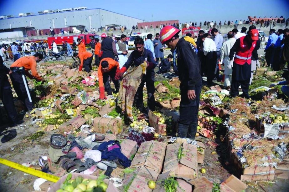 Pakistani volunteers search the site of a bomb explosions at the fruit and vegetable market in Islamabad on Wednesday killing at least 21 people and leaving dozens more wounded, officials said.