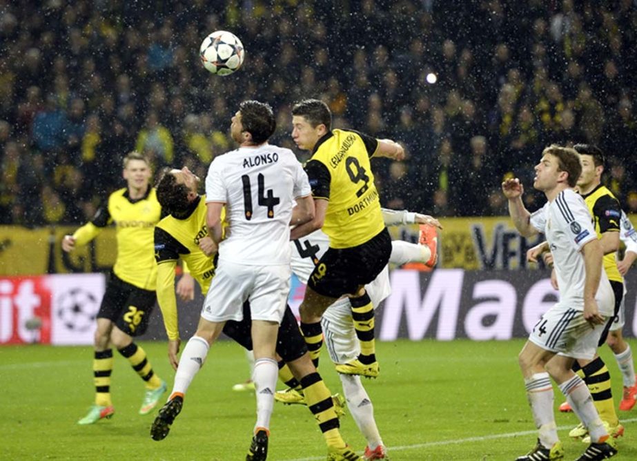 Real's Xabi Alonso fights for the ball with Dortmund's Robert Lewandowsk (right) and Henrikh Mkhitaryan during the Champions League quarterfinal second leg soccer match between Borussia Dortmund and Real Madrid in the Signal Iduna stadium in Dortmund, G