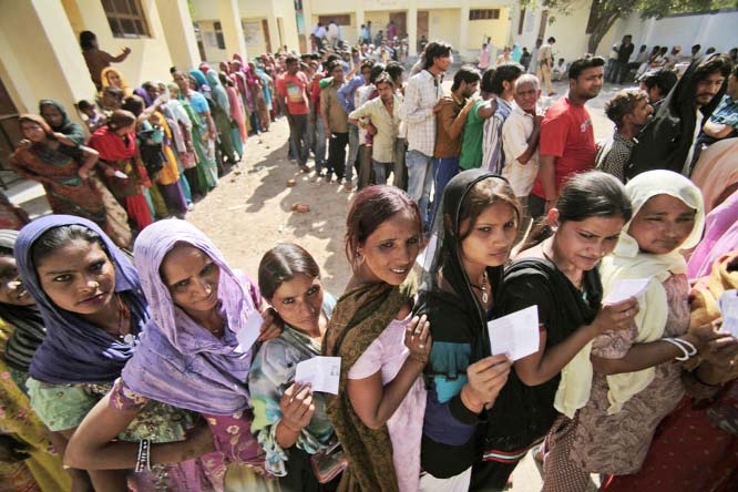 Indians stand in a queue to cast their votes outside a polling station during parliamentary elections in Jammu, India on Thursday. Millions of people are voting in the third phase of the elections, covering parts of 11 of India's 28 states. The multiphas