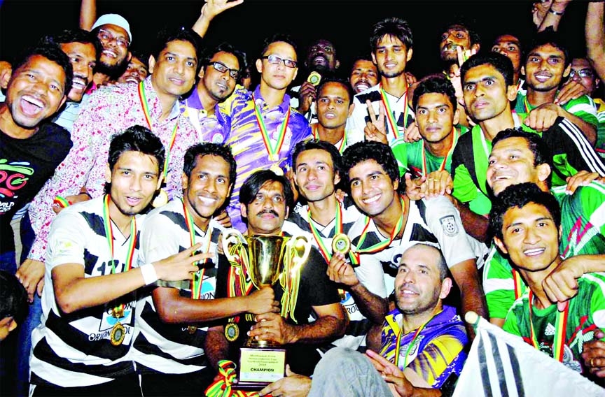 Players of Mohammedan Sporting Club pose in a group photo with the Independence Cup after beating Soccer Club, Feni in tie-breaker at the Bangabandhu National Stadium on Saturday. (Story on page 7).