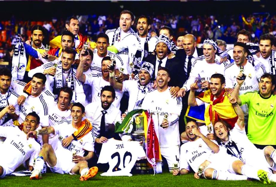 Real Madrid players celebrate with the trophy at the end of the final of the Copa del Rey between FC Barcelona and Real Madrid at the Mestalla stadium in Valencia, Spain on Wednesday. Real defeated Barcelona 2-1.