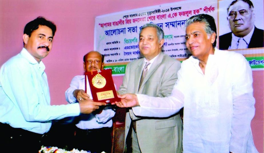 Former Chief Justice M Tafazzal Islam giving Sher-e-Bangla Medal to Aminul Haque Babul, Chairman of Glory Bandhuprotim Samaj Kalyan Sangstha for his contribution in social services at the Public Library Auditorium in the city on Friday.