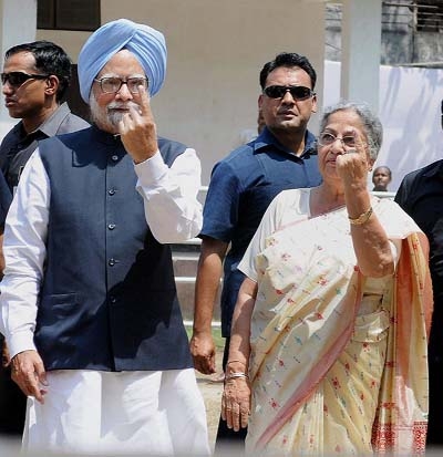 Prime Minister Manmohan Singh and his wife Gursharan Kaur showing the ink mark on their fingers after casting votes for Lok Sabha polls at Dispur in Assam..