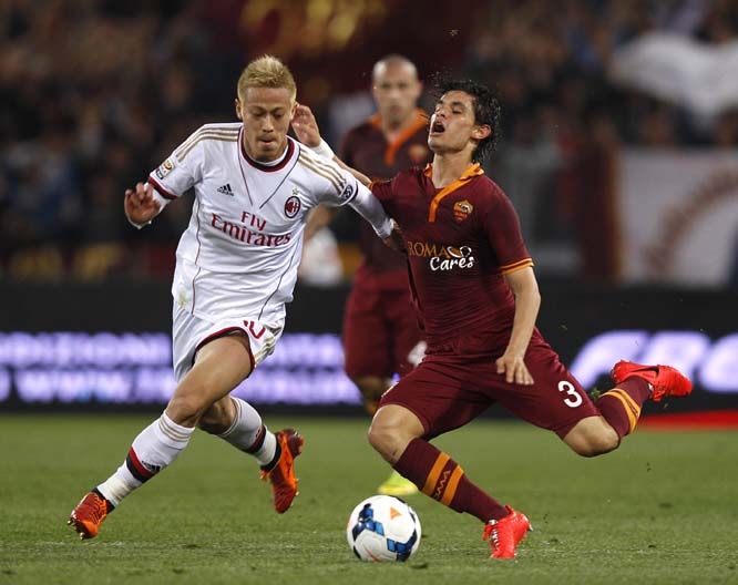 AC Milan's Keisuke Honda (left) fouls Roma defender Dodo' of Brazil during an Italian Serie A soccer match between Roma and AC Milan at Rome's Olympic stadium on Friday.