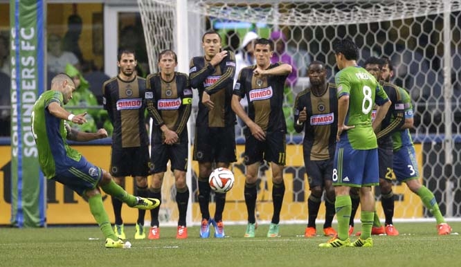 Philadelphia Union players make a wall as Seattle Sounders' Clint Dempsey (left) takes a penalty kick in the first half of an MLS soccer match in Seattle on Saturday.
