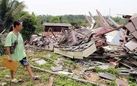 Thai woman Wallada Wiranondburapat, 34, looks at her collapsed house following an earthquake in Chiang Rai province, northern Thailand.