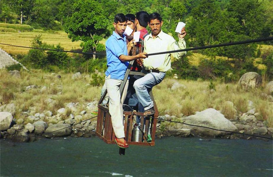 People use a rope-way on their way to cast votes for Lok Sabha polls in Chamba on Wednesday.