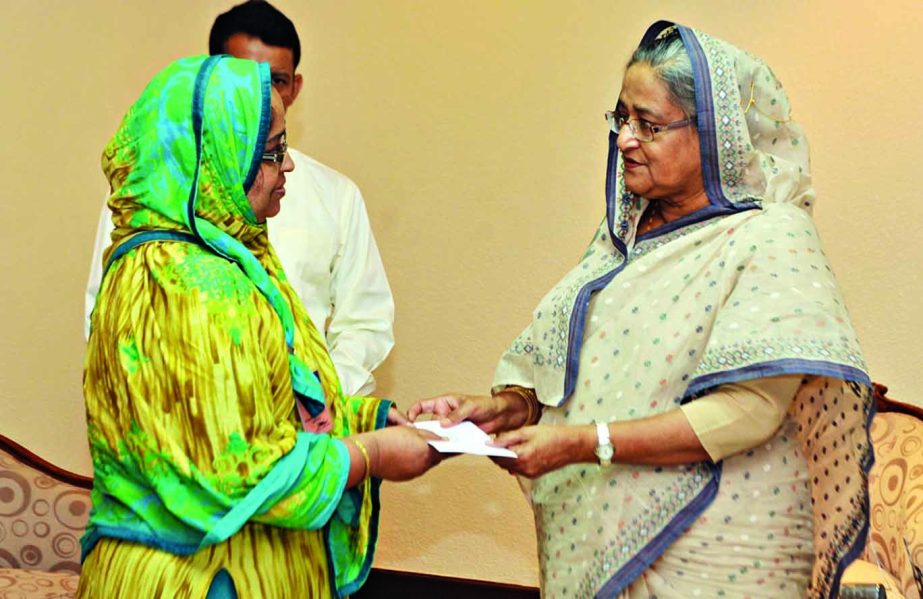 Prime Minister Sheikh Hasina handing over cheque of financial assistance to one gallantry award recipient freedom fighter/ heir at her office in the city on Wednesday. BSS photo