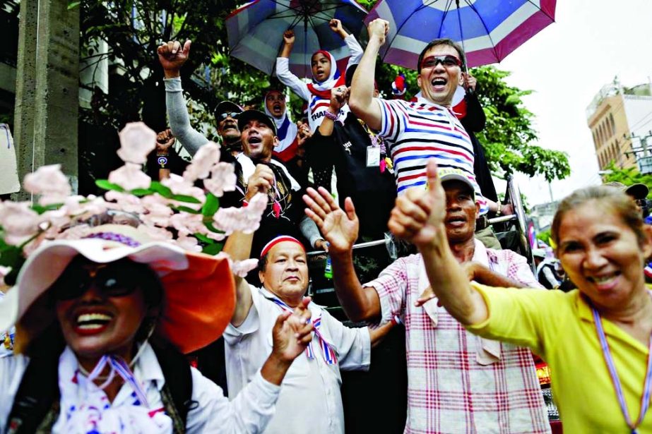 Anti-government protesters marching in the city centre celebrate moments, after a Thai court gave its verdict on Prime Minister Yingluck Shinawatra at the Constitutional Court in Bangkok.