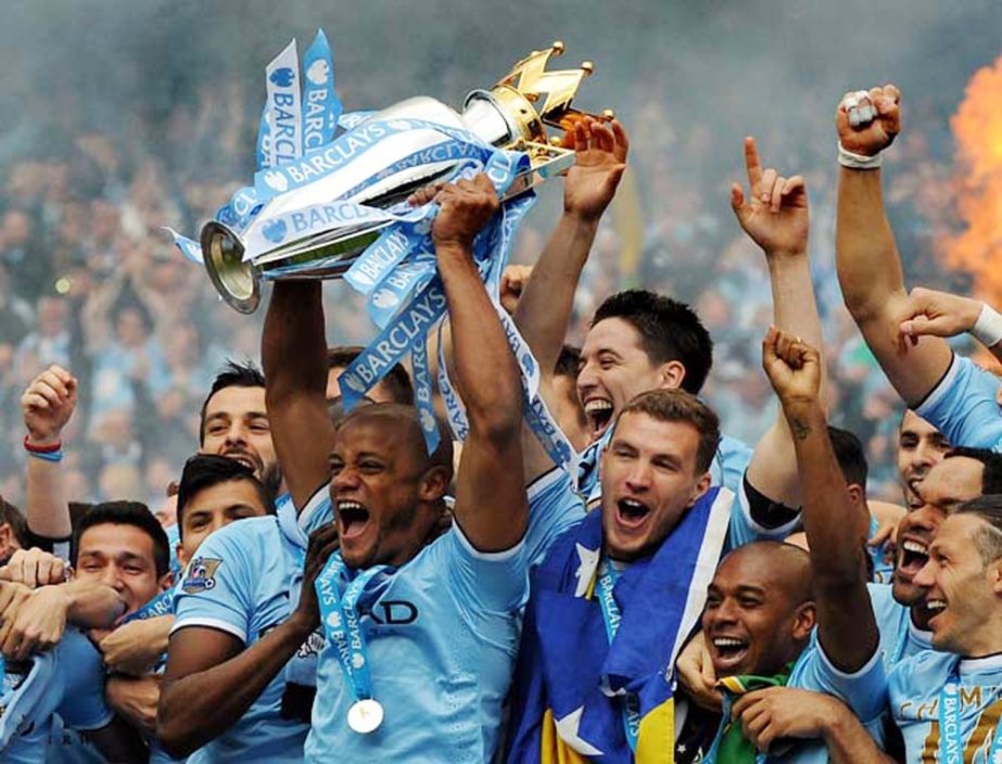 Manchester City's players captain Vincent Kompany (center) holds the Cup and celebrates with teammates after being crowned Premier League Champions, after the English Premier League soccer match between Manchester City and West Ham United at the Etihad S