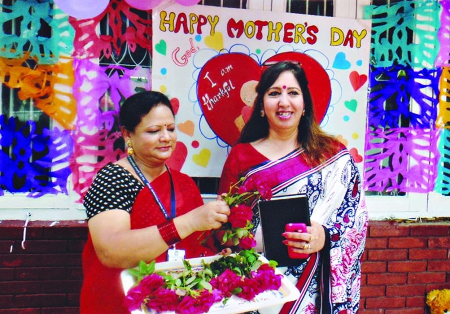 Principal of The City School International Maria Kashif greeted a guardian by giving flower on the occasion of World Mother's Day at the school premises in the city's Gulshan on Sunday.