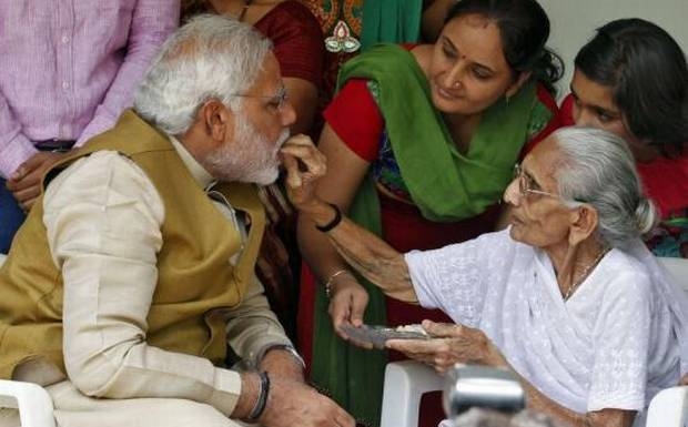 BJP prime ministerial candidate Modi (L), seeks blessings from his mother Heeraben at her residence in Gandhinagar, in Gujarat