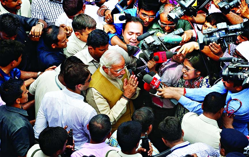 Bharatiya Janata Party (BJP) leader and India's next Prime Minister Narendra Modi greets the media as he leaves the residence of his 90-year-old mother in Gandhinagar, in the western Indian state of Gujarat.