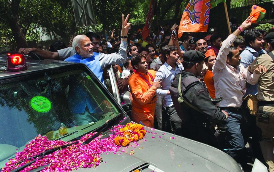Bharatiya Janata Party (BJP) leader and India's next prime minister Narendra Modi greets the crowd with a victory symbol outside the party headquarters in New Delhi.