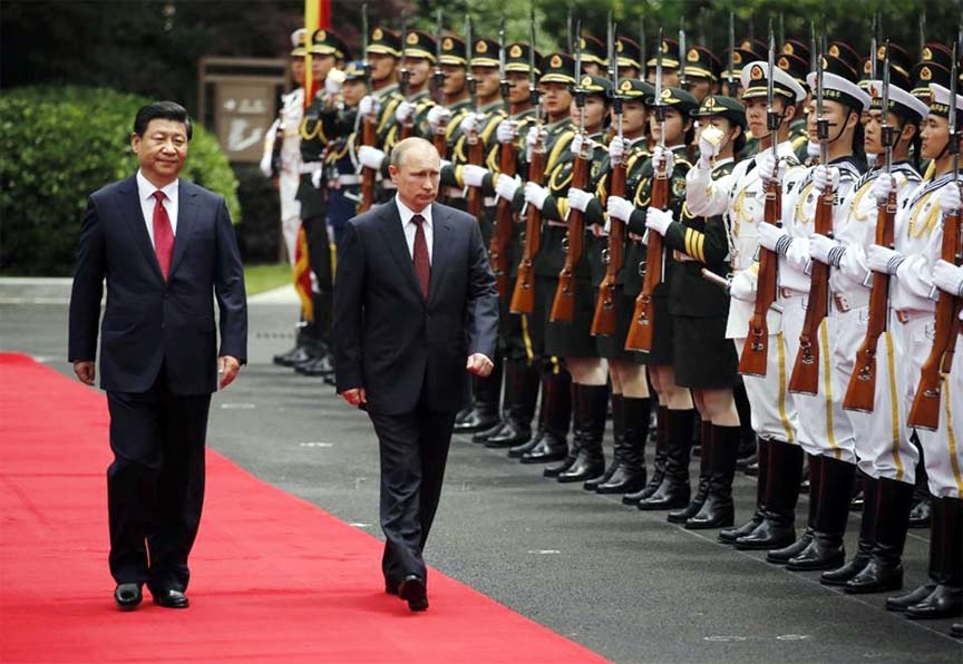 Russia's President Vladimir Putin, center, and China's President Xi Jinping, left, review an honor guard during a welcoming ceremony at the Xijiao State Guesthouse ahead of the fourth Conference on Interaction and Confidence Building Measures in Asia (C