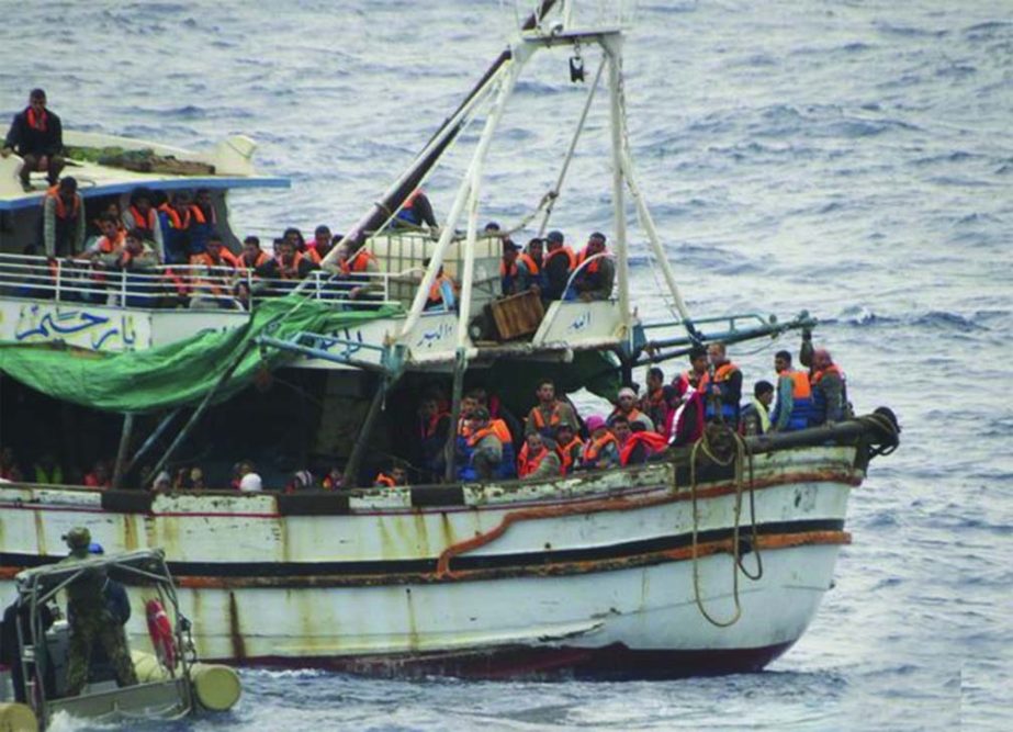 Italian sailors approach a boat carrying migrants off Sicily on Tuesday.