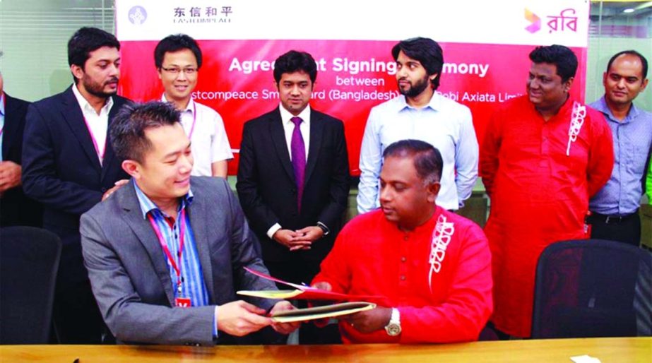 Mahtab Uddin Ahmed, Chief Operating Officer, Robi Axiata Limited and Ron Lim, Managing Director of Eastcompeace Smart Card (BD) LTD, a self-service recharge KIOSK company, exchanging a signed document to enhance mobile phone balance recharge facilities t