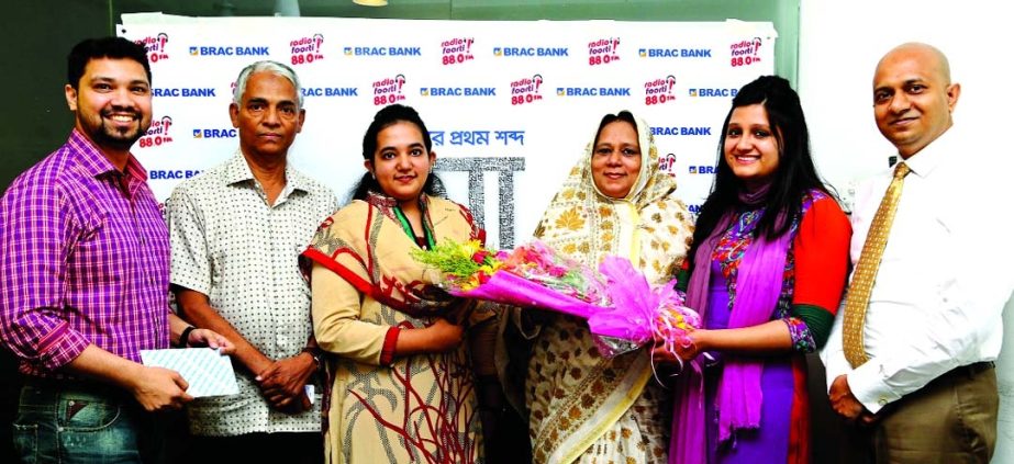 Zeeshan Kingshuk Huq, Head of Communication & Service Quality of BRAC Bank Limited and RJ Sadia of Radio Foorti handing over gift to winners of a story telling programme 'Asthar Prothom Shobdo Ma' Musharrat Tarannum Baishakhi and her mother at radio sta