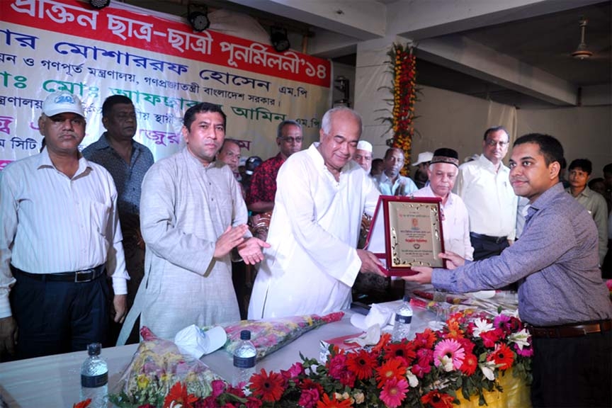 Former students of Mostafa-Hakim University College presenting crest to Housing and Public Works Minister Engr Mosharraf Hosaain MP at the re-union function of students of the college yesterday.