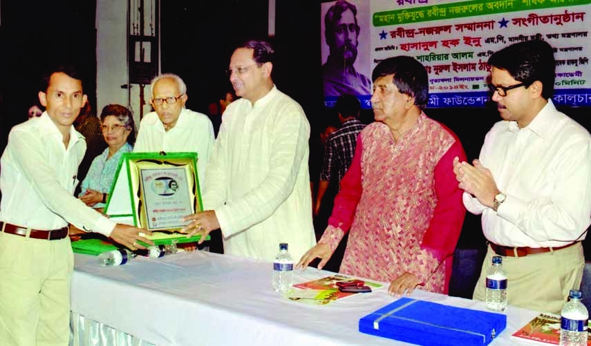 Information Minister Hasanul Haq Inu handing over Rabindra-Nazrul citation to Nazrul organizer Alauddin Bhuiyan at a ceremony organized recently at Shilpakala Academy auditorium in the city by Asia Culture Society.