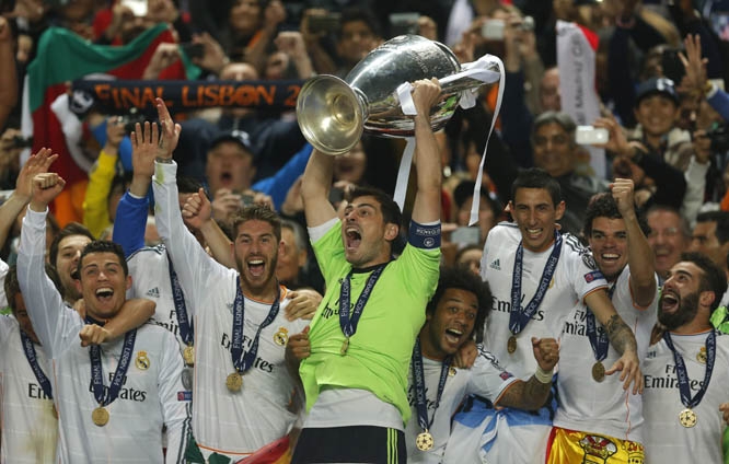 Real goalkeeper Iker Casillas (centre) lifts the Champions League trophy as he and teammates celebrate winning the Champion League title, against Atletico Madrid in Lisbon, Portugal on Saturday.