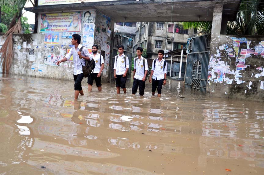 Students struggle through the knee-deep water as the roads were submerged by rain. The snap was taken from in front of Dania University College on Monday.