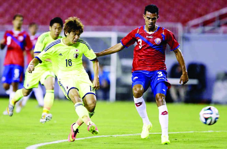 Japan forward Yuya Osako (18) gets off a shot in front of Costa Rica defender Giancarlo Gonzalez (3) during the first half of a friendly soccer match in Tampa, Fla on Monday.