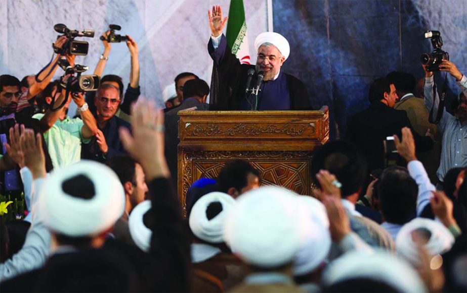 Iranian President Hassan Rouhani waves as he arrives to deliver a speech during a ceremony marking the 25th death anniversary of Ayatollah Khomeini, the founder of the Islamic Republic, at his shrine just outside Tehran, Iran.