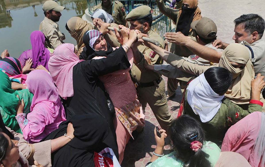 Workers of Anganwadi, a government sponsored child and mother care, scuffles with Indian police trying to stop them marching forward during a protest in Srinagar.