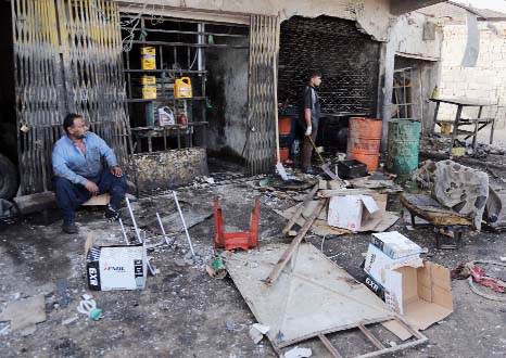 Civilians inspect the aftermath of a car bomb explosion at an industrial area in Baghdad's eastern Ur neighborhood, Iraq on Sunday.