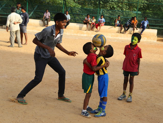 Indian children with faces painted in colors resembling those of the Brazil's flag place the ball on their faces as others watch, during a game of soccer in Bangalore, India on Tuesday. Soccer fans around the world are gearing up to watch the World Cup s
