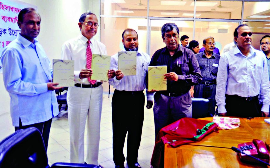 Comptroller and Auditor General, Bangladesh Masud Ahmed along with other distinguished guests holds the copies of a book titled 'Basic accounting system and its practical implication' at its cover unwrapping ceremony held recently at Audit Bhaban in the
