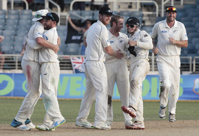 New Zealand's cricket players celebrate on the pitch at the end of their first cricket Test match against West Indies in Kingston, Jamaica on Wednesday. New Zealand won by 186 runs.