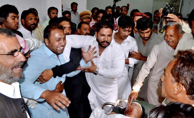 Pakistani men mourn over the body, bottom right, of a provincial lawmaker Handery Masieh at a local hospital in Quetta, Pakistan on Saturday.