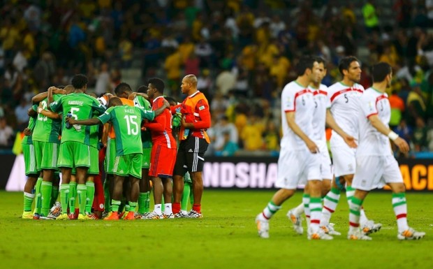 Nigeria players huddle, as Iran players walk past, at the end of their 2014 World Cup Group F soccer match at the Baixada arena in Curitiba June 16, 2014. Credit: Reuters