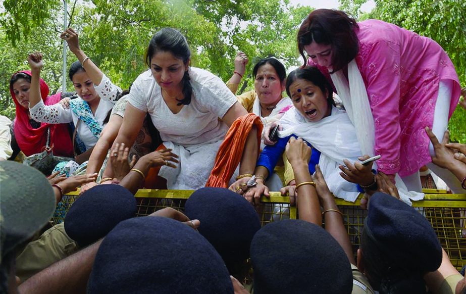 Women Congress workers try to break a barricade during a protest demanding resignation of Minister of State Nihal Chand in New Delhi.