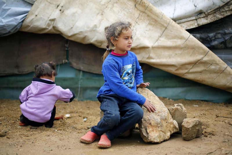 Iman, 8 , A Syrian refugee, sits in the Fadaya Camp some 25 miles east of Beirut on Sunday.