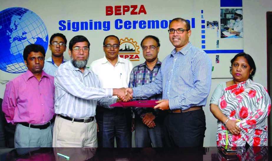 Sayed Nurul Islam, Member (Investment Promotion) of Bangladesh Export Processing Zones Authority and Monirul Islam Khan, Managing Director of HASFAB Wear Limited exchanging signed document at BEPZA Complex on Thursday.