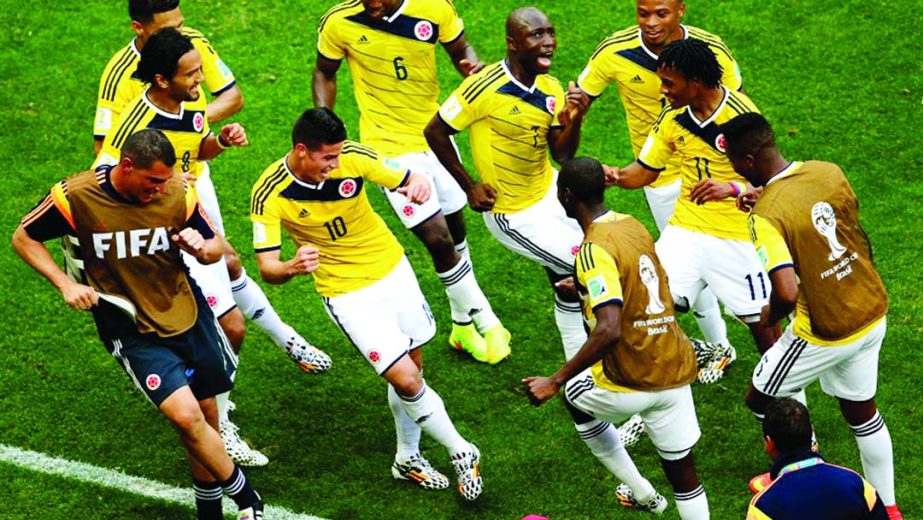 James Rodriguez (10) of Colombia celebrates by dancing with teammates after scoring his team's first goal during the 2014 FIFA World Cup Brazil Group C match between Colombia and Ivory Coast at Estadio Nacional in Brasilia, Brazil on Thursday.