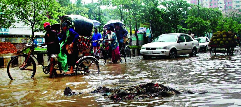 City streets went under ankle deep water due to poor drainage system in a short spell of rains. This photo was taken from Outer Circular Road near Rajarbagh Police Line on Friday.