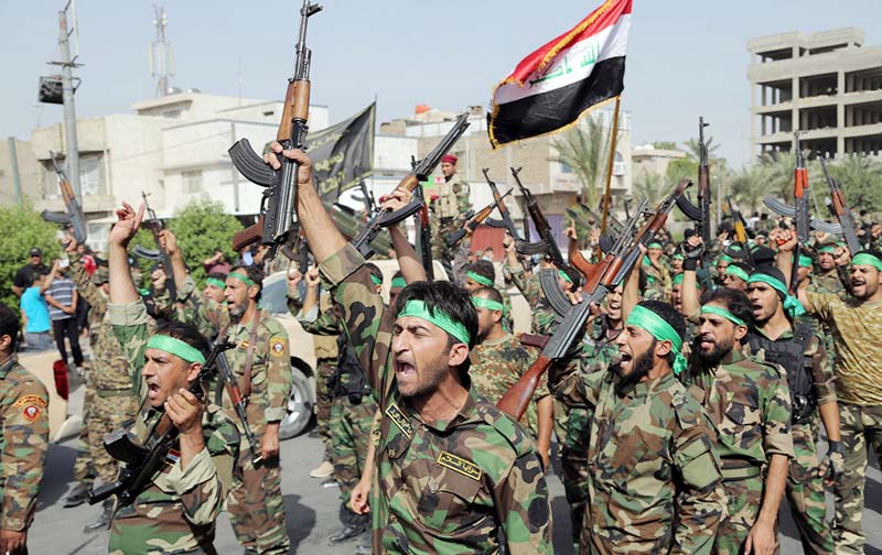 Volunteers of the newly formed 'Peace Brigades' raise their weapons and chant slogans against the al-Qaida-inspired Islamic State of Iraq and the Levant during a parade in the Shiite stronghold of Sadr City, Baghdad.